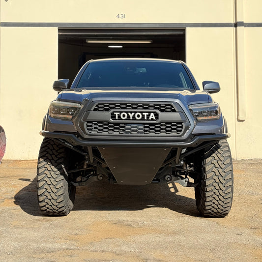Toyota truck parked in front of a beige building with a blue sky.